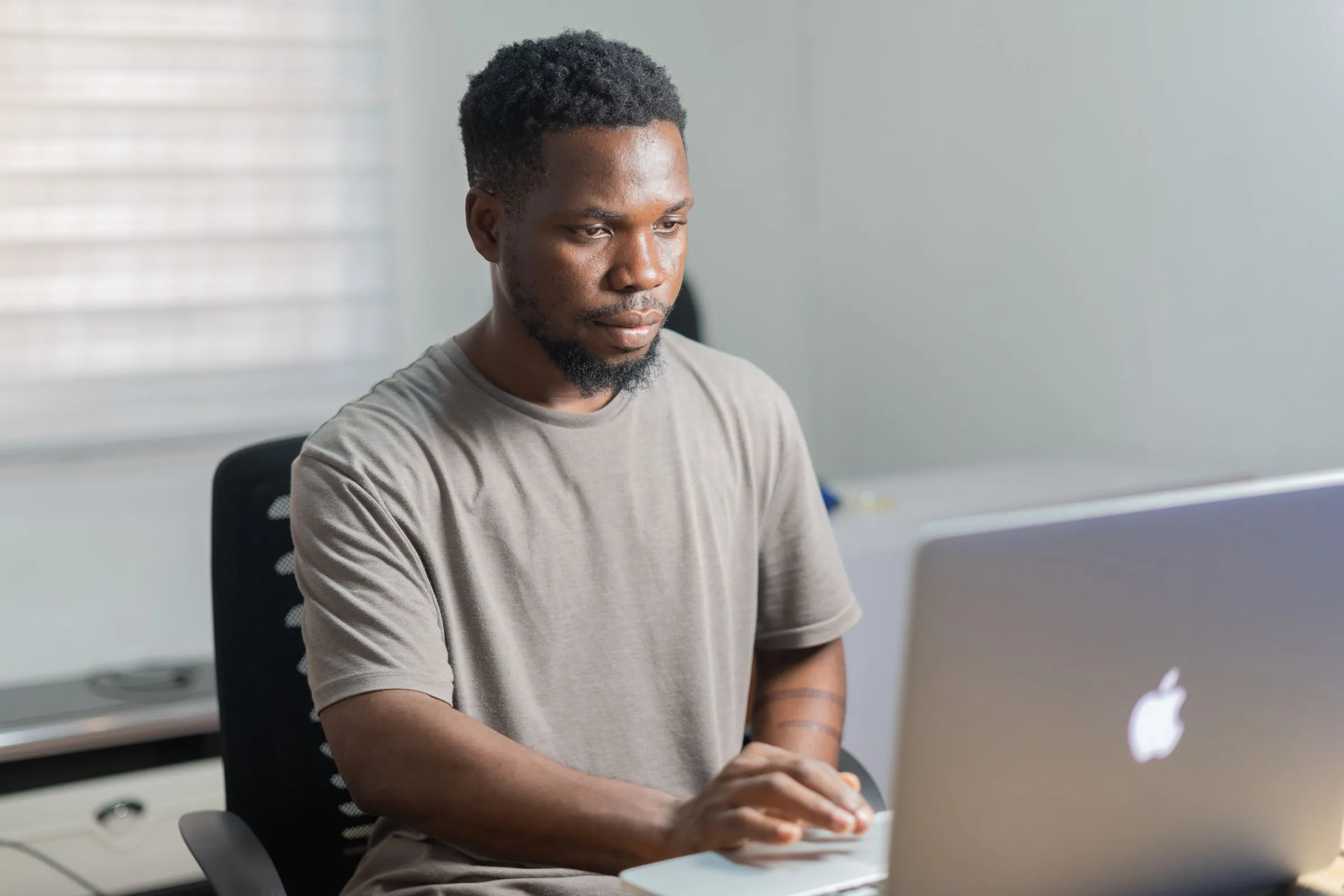 Homme qui travaille sur son ordinateur portable dans un bureau lumineux